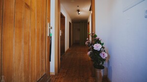 A hallway with wooden doors and a potted plant with flowers. - Apartment Hochalm at 1705m, at the foot of the Alpspitze (no access by car)  (Garmisch-Partenkirchen)