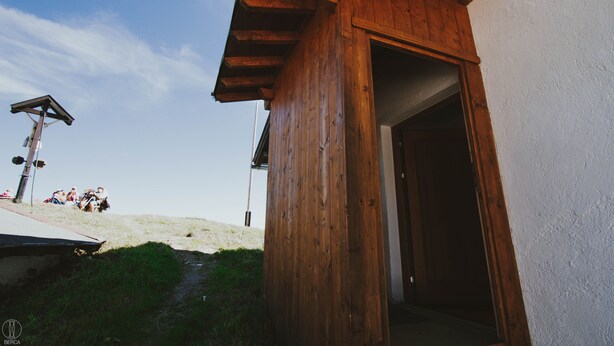 A wooden building with a sloped roof and a doorway leading inside. - Apartment Hochalm at 1705m, at the foot of the Alpspitze (no access by car)  (Garmisch-Partenkirchen)