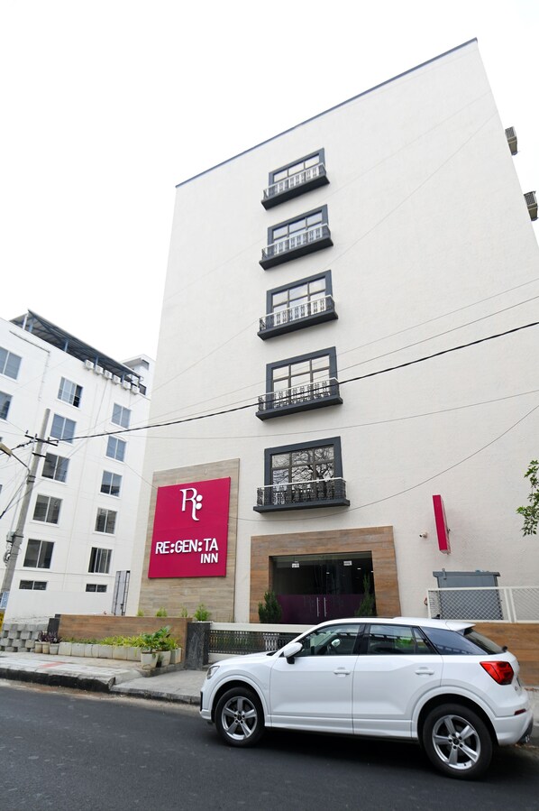 A multi-story building with a prominent red sign for RE:GEN:TA INN. - Regenta Inn Bannerghatta Bangalore (Bengaluru)