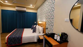 A hotel room with a bed, bedside table, and a mirror.