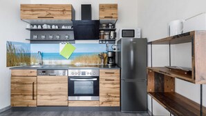 Une cuisine moderne avec des meubles en bois, un réfrigérateur en acier inoxydable et un four encastré.
