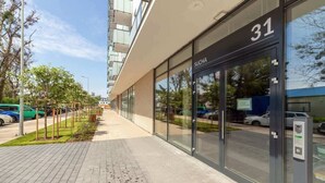 Un bâtiment moderne à la façade en verre, portant le numéro 31, avec un espace de stationnement devant.