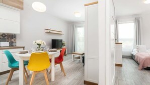 Un appartement moderne comprenant un coin repas, un salon et une chambre.
