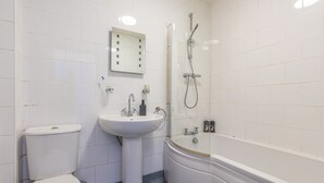 A bathroom with a toilet, sink, and bathtub. - Bloomfield 1 (Lancaster)