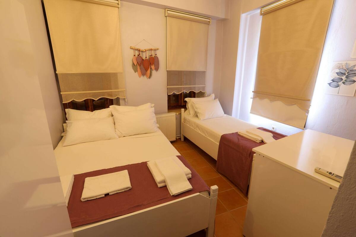 Una habitación de hotel con dos camas individuales, un escritorio pequeño y un refrigerador.