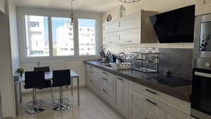 Una cocina moderna con comedor, ventanas amplias y vista a la ciudad.