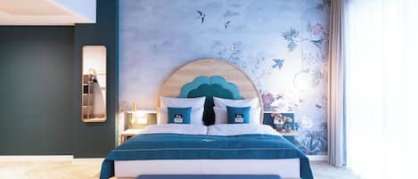 A modern bedroom with a large bed, a unique wall mural, and a view of the outdoors.