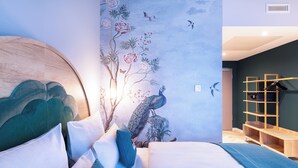 A modern bedroom with a large bed, a wooden headboard, a wall mural, and a built-in shelving unit. - Holiday Inn - the niu, Flower Konstanz by IHG (Konstanz)