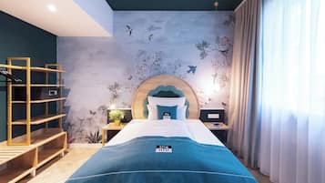 A bedroom with a bed, a wooden shelf unit, a nightstand, and a wall mural.
