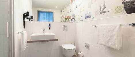 A modern bathroom with a toilet, sink, and towel rack.