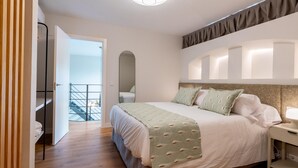 A modern bedroom with a large bed, a bedside table, a mirror, and a view of a balcony. - LF PARKING INCLUDED. Loft adjacent to Santa Cruz (Sevilla)