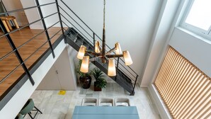 A modern interior with a staircase, a dining area with a table and chairs, and a hanging light fixture. - LF PARKING INCLUDED. Loft adjacent to Santa Cruz (Sevilla)