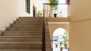 Una scala conduce a un balcone con piante in vaso.