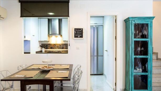A modern kitchen with a gas stove, a stainless steel refrigerator, and a dining area with a table and chairs. - LR2 PRIVATE TERRACE and parking included. Apartment in the Historic Center (Sevilla)