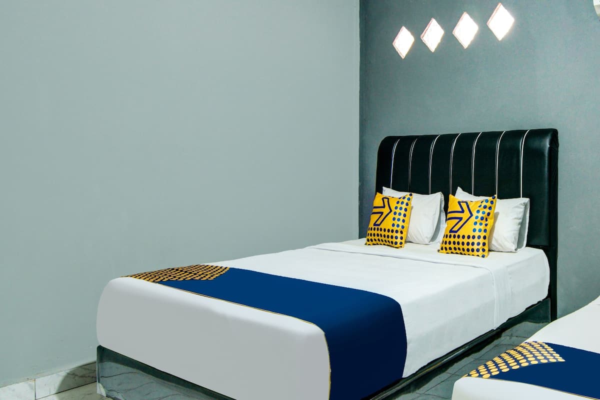 Ein Hotelzimmer mit einem Bett, einem Nachttisch und einer Wandleuchte.