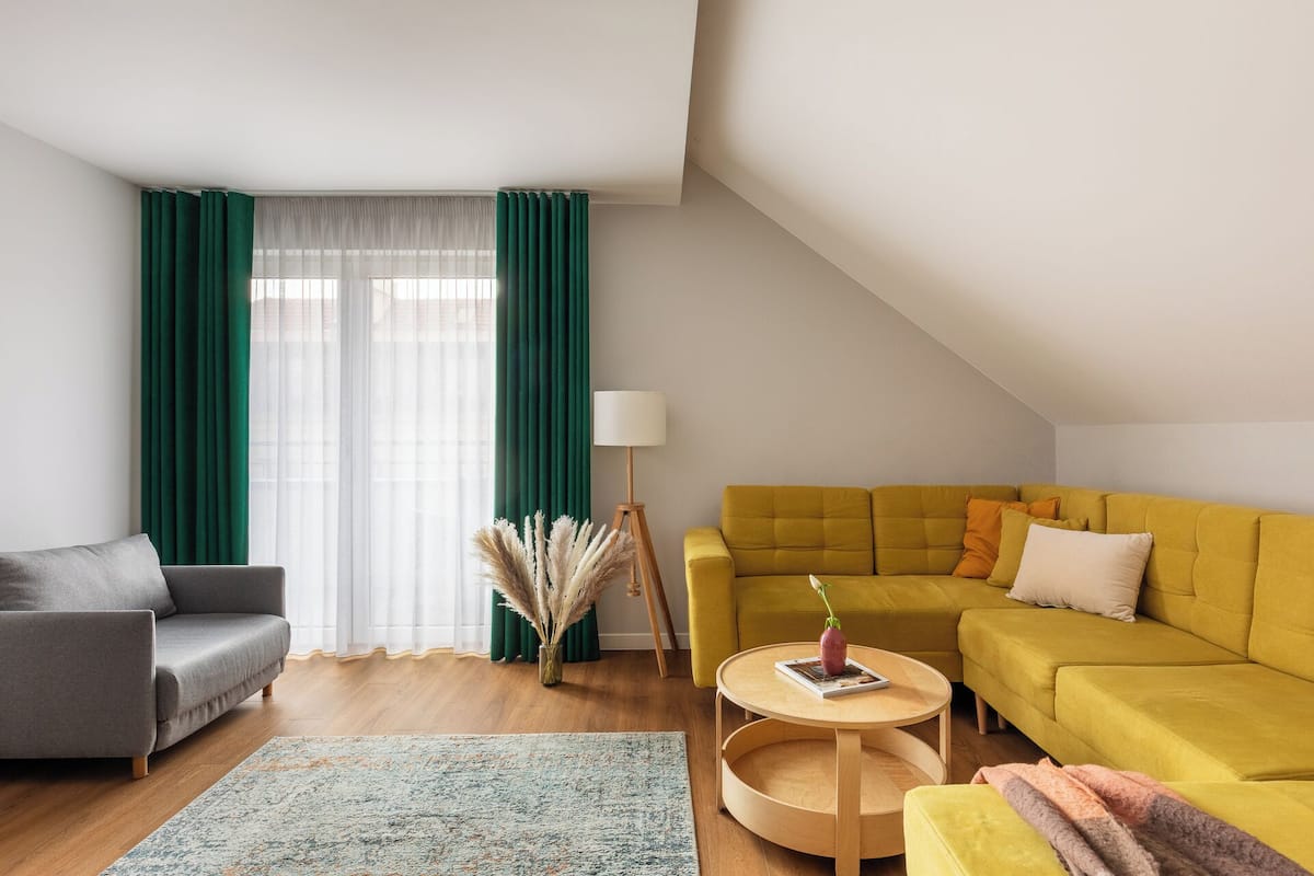 Una sala moderna con un sofá, un sillón y una mesa redonda de centro.