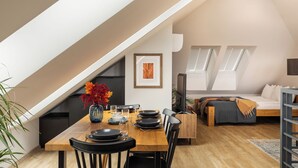 A modern loft apartment with a dining area, a sofa, and a TV. - Trevi Apartments Tychy (Tychy)