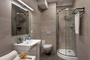 Apartamento básico | Baño | Ducha, cabezal de ducha tipo lluvia, secador de pelo y toallas