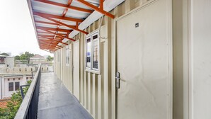 A corridor with a metal railing, beige walls, and a door marked with the number 64. - Capital O 3300 Nadjara Residence Syariah (Pekanbaru)