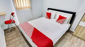 A neatly made bed with a white and red bedspread, two pillows, and a red throw blanket. - Capital O 3300 Nadjara Residence Syariah (Pekanbaru)