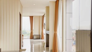 A modern hotel room with a large window, a flat-screen TV, and a view of the city.