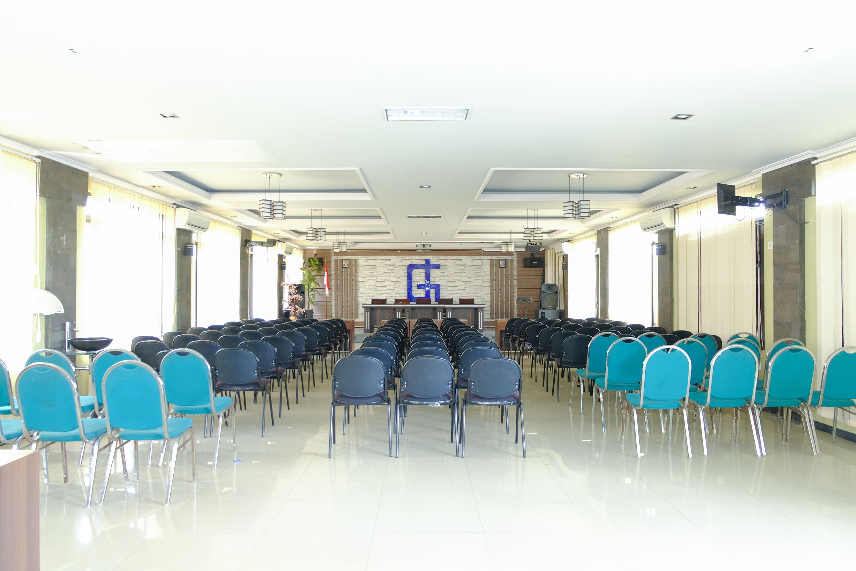 A conference room with rows of chairs and a podium at the front.