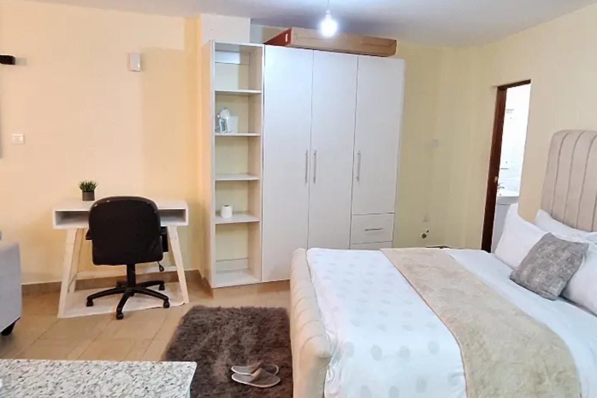 Ein Schlafzimmer mit Bett, Schreibtisch und Kleiderschrank.