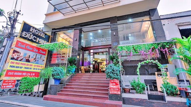 A hotel entrance with a staircase leading up to the door, surrounded by greenery and potted plants. - S79 Quynh Giang Airport Hotel (Ho Chi Minh City)