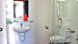 A bathroom with a white sink, glass shower enclosure, and a glass door. - S79 Quynh Giang Airport Hotel (Ho Chi Minh City)
