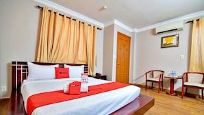 A hotel room with a large bed, a bedside table, a small table with chairs, and a door. - S79 Quynh Giang Airport Hotel (Ho Chi Minh City)