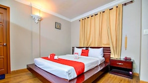 A hotel room with a bed, a nightstand, a lamp, and a curtain. - S79 Quynh Giang Airport Hotel (Ho Chi Minh City)