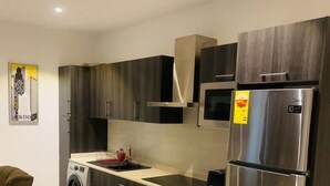 Une cuisine moderne avec des meubles en bois foncé, des appareils électroménagers en acier inoxydable et un four encastré.