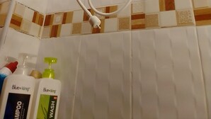 Une douche équipée d’un pommeau de douche à main et d’une douchette fixée au mur.