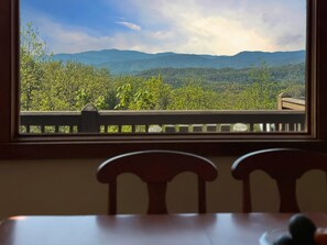A room with a view of a mountainous landscape through a window. - Bear Necessities - 2BR, sleeps up to 6, amazing view, hot tub + free Biltmore tix (Sylva)
