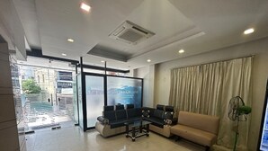 A modern waiting area with a sofa, a small table, and a large screen displaying 'LIVE LAUGH LOVE'. - Ranas Residency (Tiruchirappalli)