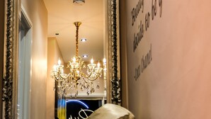 A mirror with a decorative frame, a chandelier, and a wall with a motivational quote. - NoTwenty9 Bar and Restaurant  (King's Lynn)