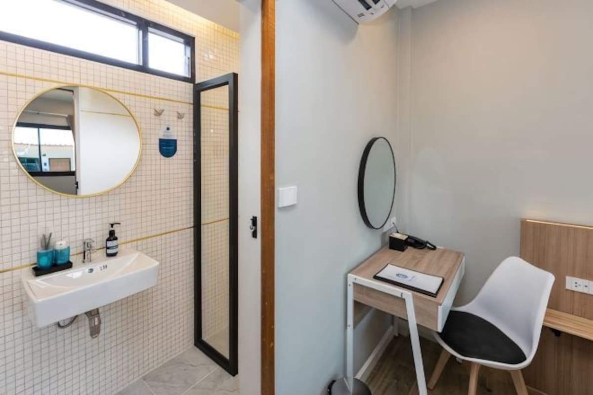 Ein Badezimmer mit Waschbecken, Spiegel und Stuhl.