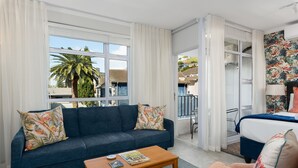 Un salon avec un canapé, une table basse et une vue sur un balcon.