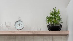 Une cuisine moderne équipée d’un four à micro-ondes, d’une machine à café et d’une plante en pot posée sur le plan de travail.