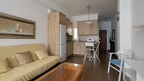 Une cuisine moderne avec des meubles en bois, un réfrigérateur blanc et un coin repas comprenant une chaise et une table blanches.