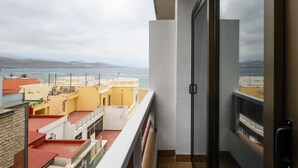 Un balcon avec vue sur la mer et les montagnes lointaines.