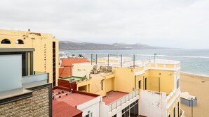 Un bâtiment situé sur la côte, offrant une vue sur la plage et les montagnes.