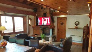 A cozy living room with a fireplace, wooden furniture, and a television. - N5 Chalet apartment4****South West 10/11 guests/Slopes foot (Val-d'Isère)