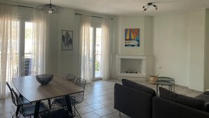 Ein großzügiger Wohnbereich mit Esstisch, Sofas und Kamin.