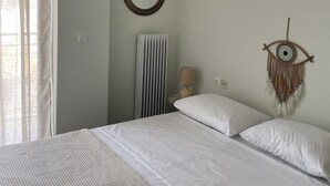 Ein Schlafzimmer mit einem Bett, einem runden Spiegel, einer Wanddekoration und einer Heizung.