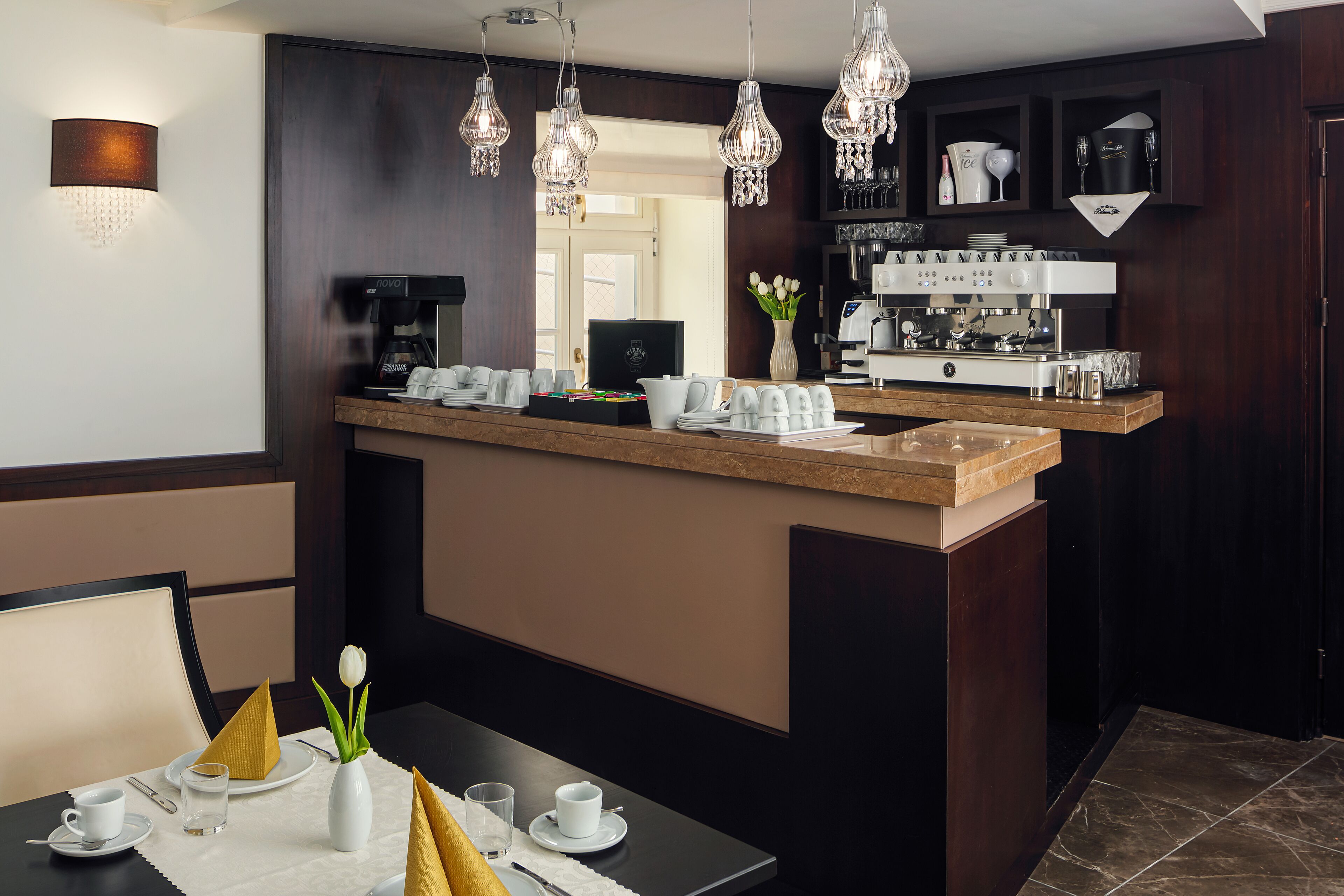 A modern kitchen with a central island, a coffee machine, and a wine cooler.