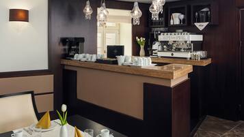 A modern kitchen with a central island, a coffee machine, and a wine cooler.