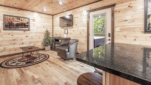 A wooden interior with a sofa, a small table, and a TV.