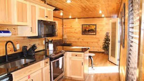 Une cuisine avec des meubles en bois, un évier en acier inoxydable, un four à micro-ondes et une cuisinière.