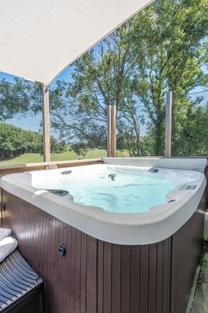 A hot tub with a wooden deck and a canopy, surrounded by trees and a fence. - Luxury Golf Villa w/ Hot Tub Stunning Golf Course Views Near OBX Beaches (Kitty Hawk)